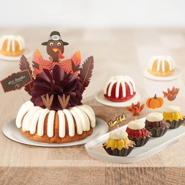Festive cake toppers featuring Give Thanks Bundt Cakes with writing feathers and Bundtinis with thankful, turkey, and pumpkin decorations