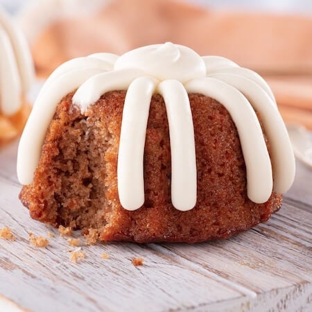 Individual Carrot Bundtlet frosted with signature frosting showing the middle of the cake - Shop Bundtlets & Towers